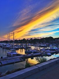 Boats moored in sea at sunset