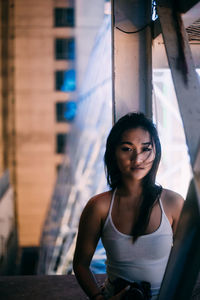 Portrait of beautiful woman in city at night