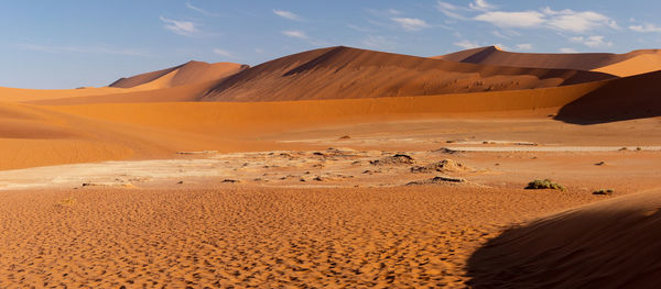 Sand dunes in desert against sky