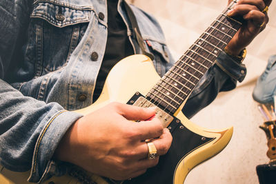 Midsection of man playing guitar