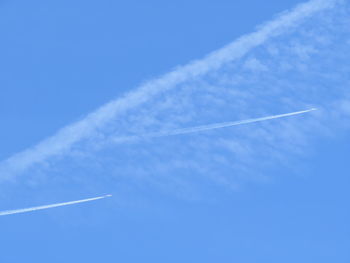 Low angle view of vapor trail against blue sky