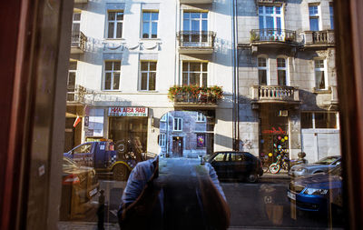 Man on street against building in city