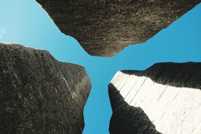 Directly below shot of sculptures against clear blue sky