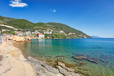 Scenic view of sea and buildings against blue sky