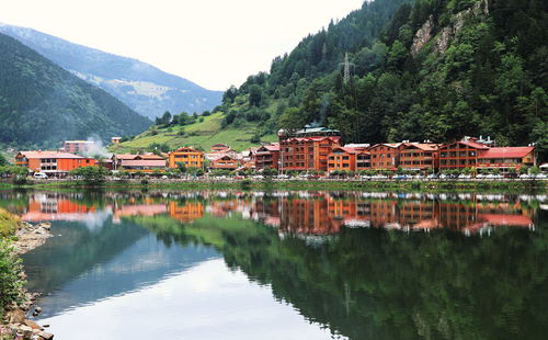 Scenic view of lake by buildings and mountains