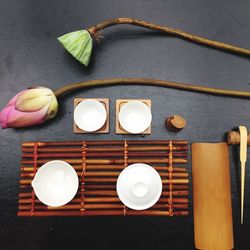 Directly above view of lotus and pod by crockery on table