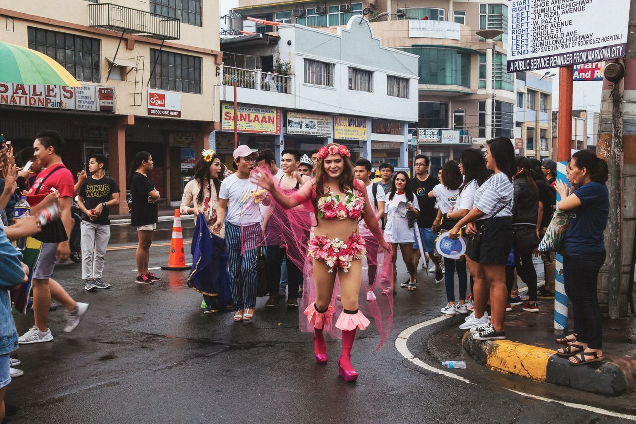 city, architecture, building exterior, real people, large group of people, built structure, women, group of people, street, crowd, lifestyles, men, leisure activity, adult, day, casual clothing, standing, city life, outdoors