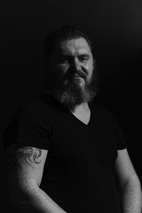 Portrait of bearded man against black background