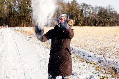 Woman standing on snow covered tree