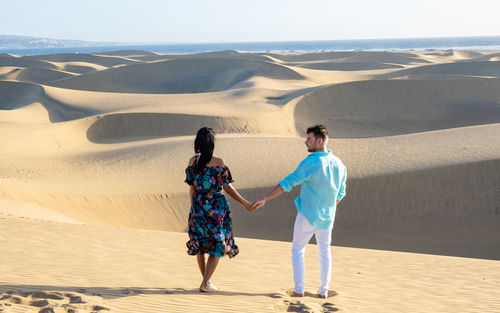 Rear view of woman standing at desert