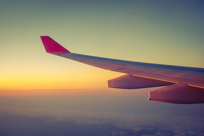 Airplane flying in sky during sunset