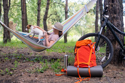 Side view of woman lying on hammock