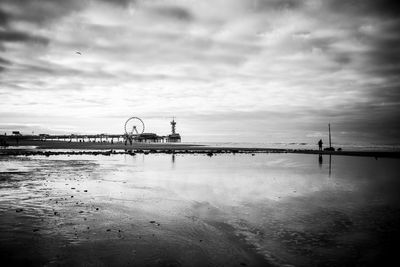 Pier over sea against cloudy sky