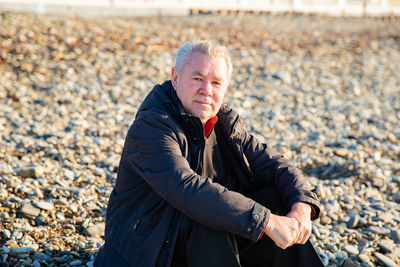 Young man with pebbles on beach