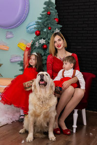 Portrait of young woman with dog on floor