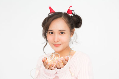 Portrait of smiling young woman against white background