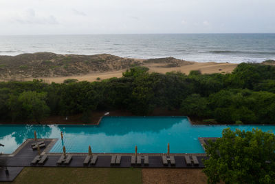 High angle view of swimming pool by sea against sky