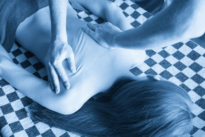 Midsection of woman lying on bed