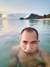 Portrait of shirtless man swimming in pool