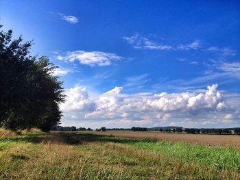 Scenic view of field against cloudy sky