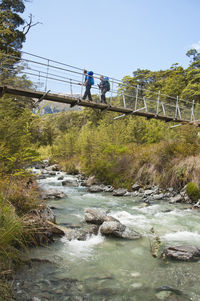 Footbridge over river against clear sky