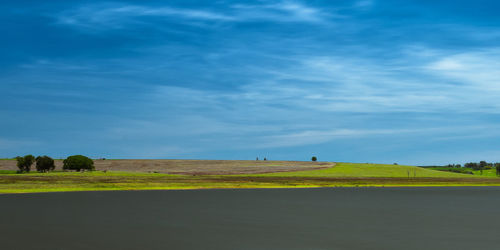 Scenic view of field against blue sky