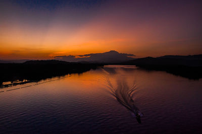 Scenic view of lake against sky at sunset