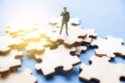 Close-up of businessman figurine on jigsaw piece