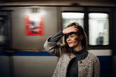 Close-up of woman standing against train