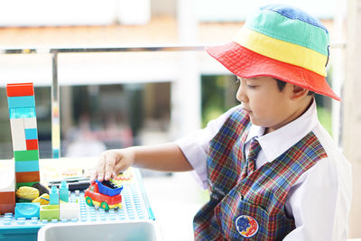 Midsection of boy holding multi colored umbrella