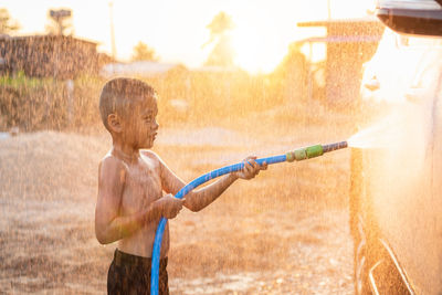 Side view of boy playing with umbrella