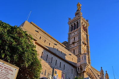 Low angle view of clock tower against blue sky