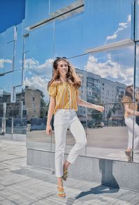 Portrait of smiling girl standing by building