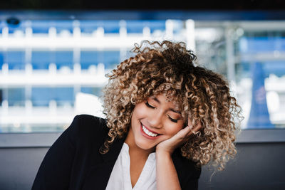 Confident hispanic business woman in cafe with eyes closed. tech and lifestyle