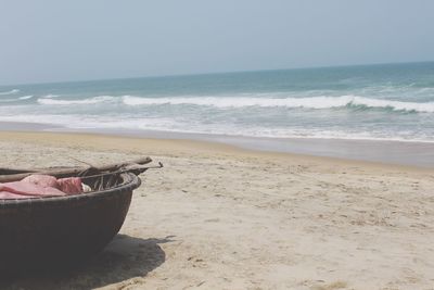 Boat moored at beach against clear sky