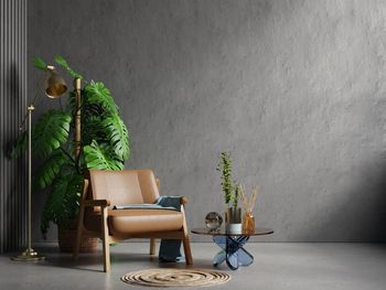 Living room interior in loft style with leather armchair on empty concrete wall background.