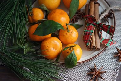 Close-up of orange fruits and cinnamon sticks on table