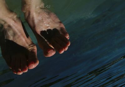 Cropped image of woman leg in river