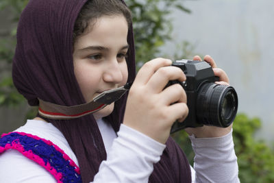 Portrait of teenage girl photographing