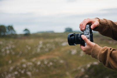 Midsection of man photographing camera