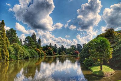 Scenic view of lake by trees against sky