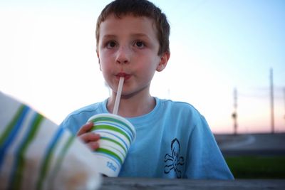 Portrait of young boy drinking