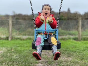 Full length of boy sitting on field