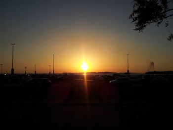 Silhouette cars against sky during sunset