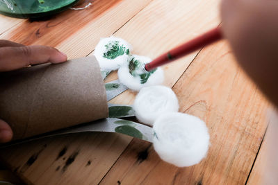 High angle view of person holding paper on table