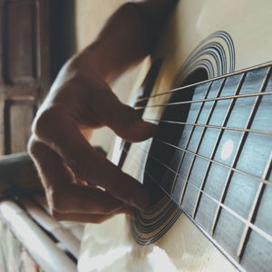 Midsection of man playing guitar