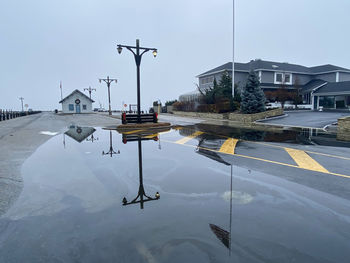 Water overflows on to  docks and road forming large and dangerous puddles for cars to drive through.