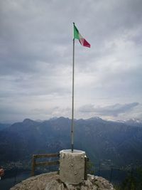 Flag against mountain range against sky