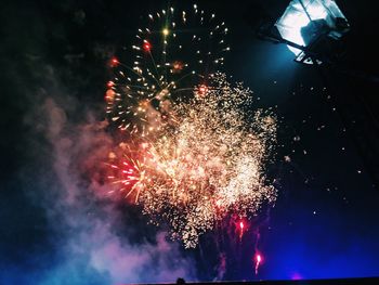 Low angle view of firework display at night