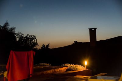 Illuminated built structure against sky at sunset